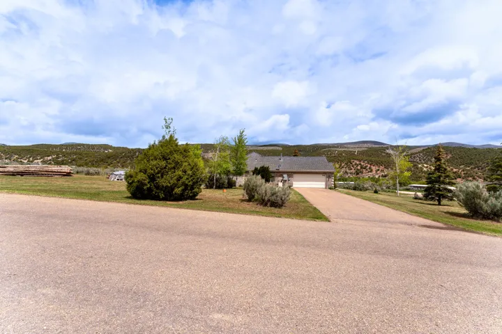 Ranch-style exterior with a front-facing garage, asphalt driveway, and a shingle roof