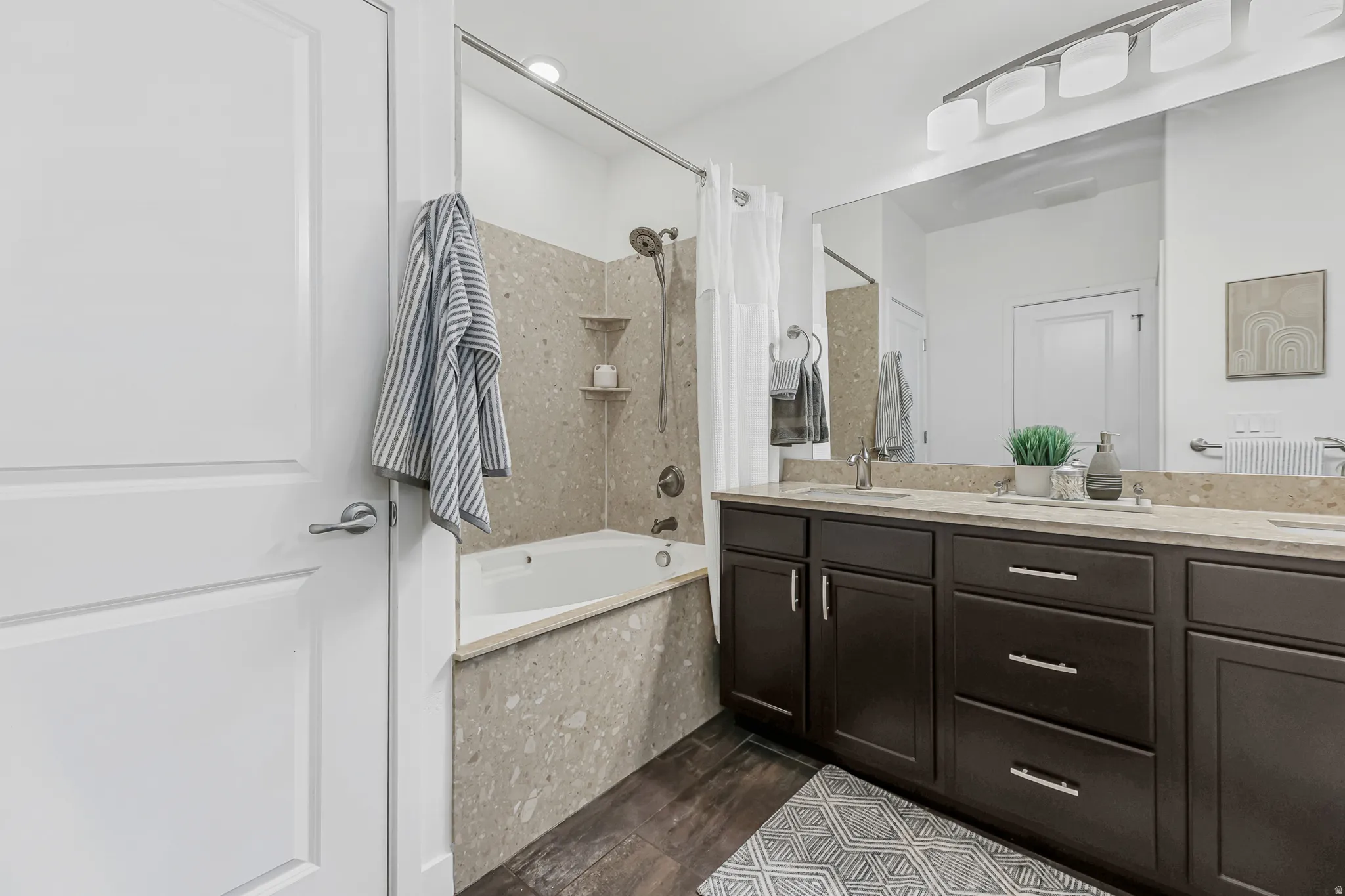 Primary bathroom featuring a double vanity with dark wood cabinetry, a light-toned countertop, and dual sinks