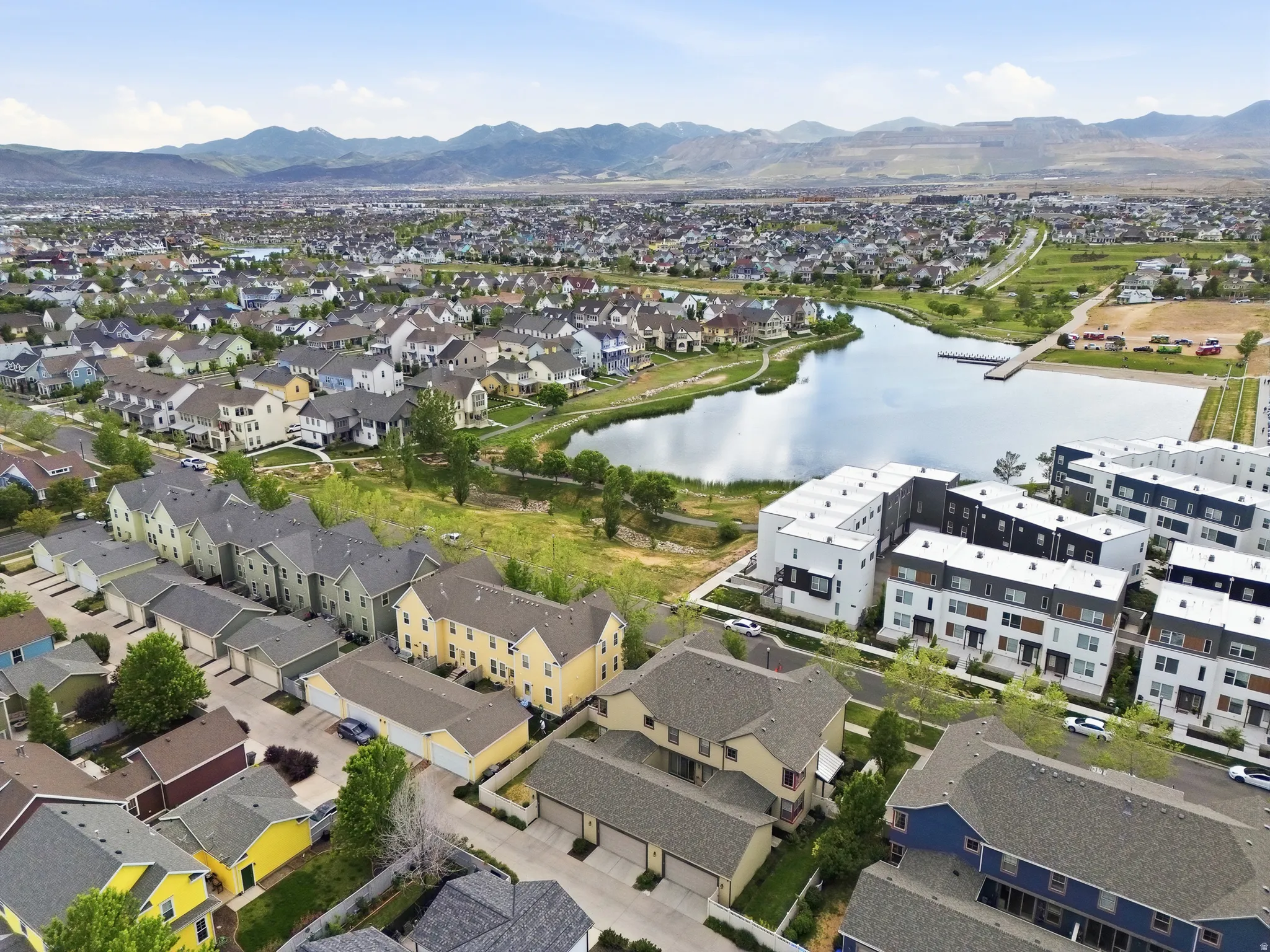 Aerial perspective showcasing a residential development with a prominent community lake