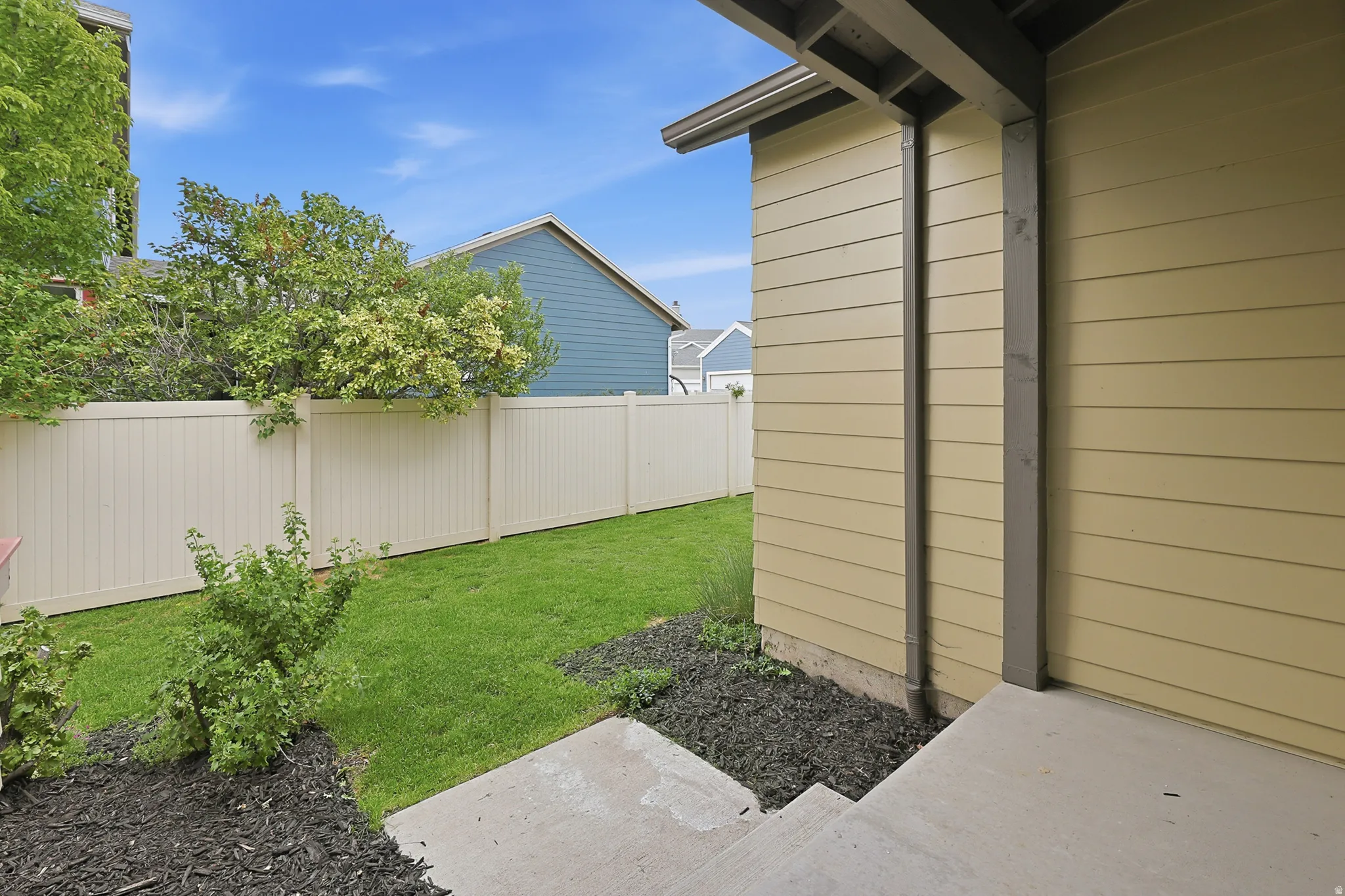 Exterior backyard patio area featuring concrete steps and a covered entry