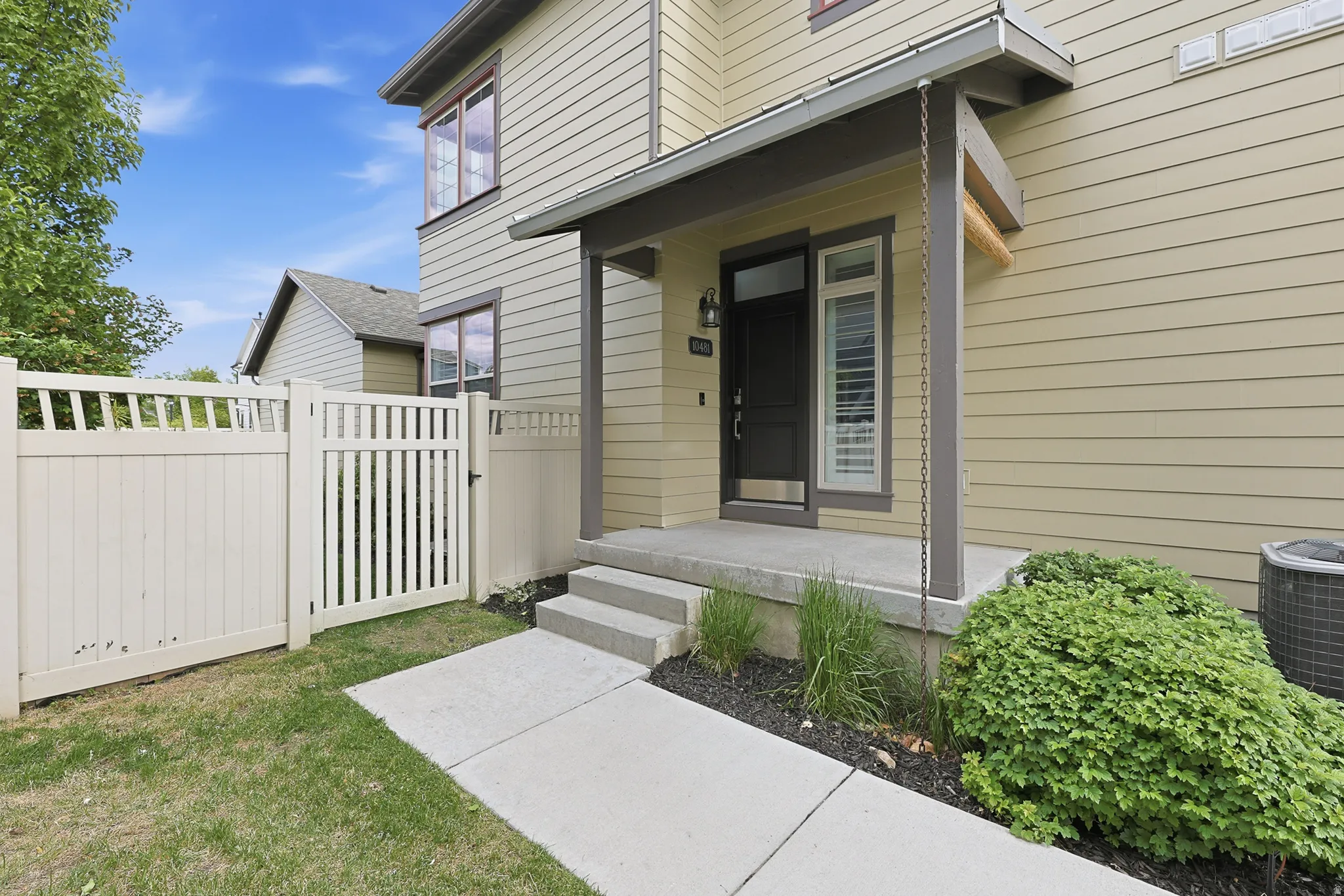 Contemporary siding exterior with a covered entry, concrete walkway