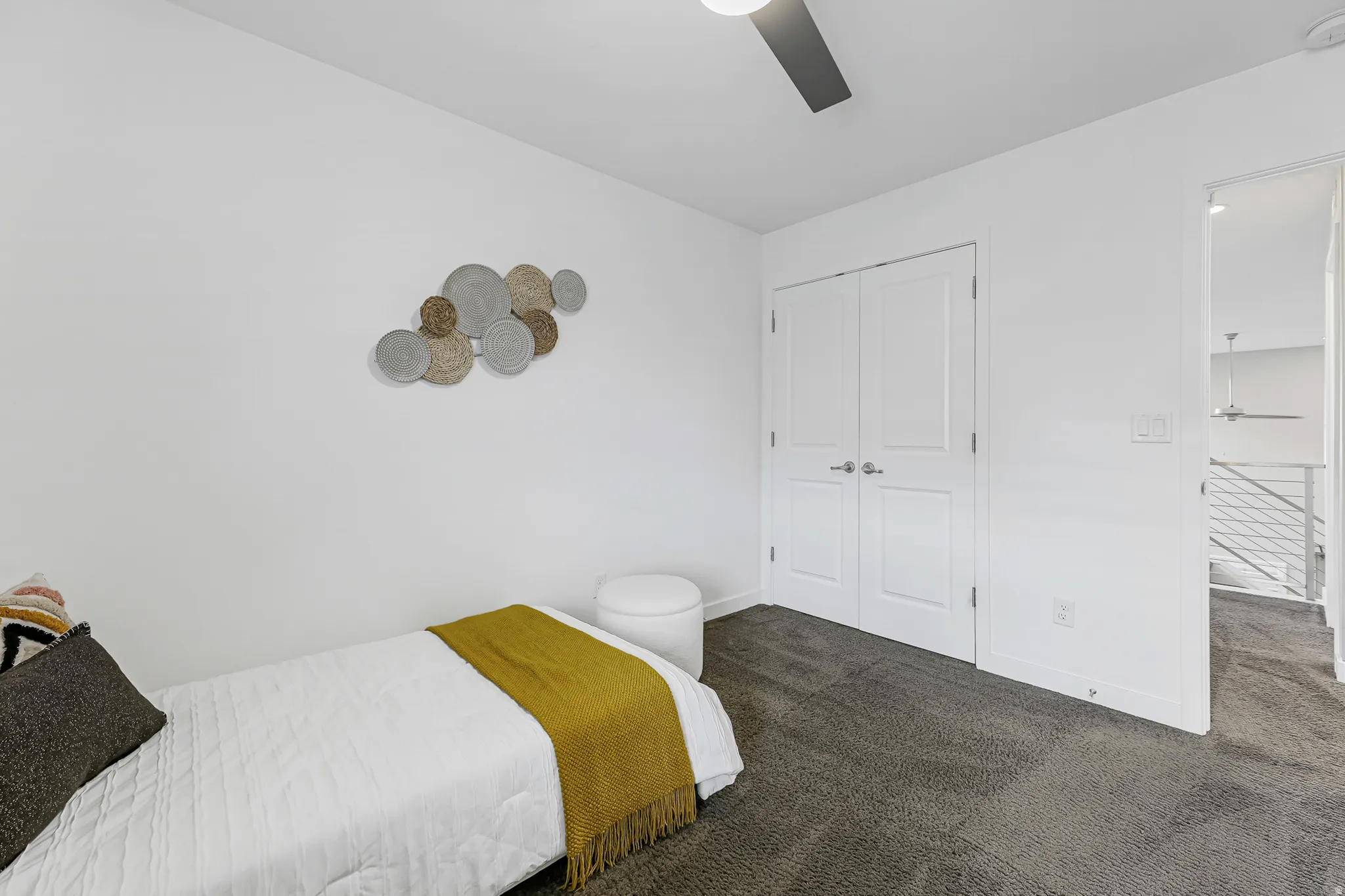 Bedroom featuring white walls, gray carpet, a modern ceiling fan, and white bifold closet doors