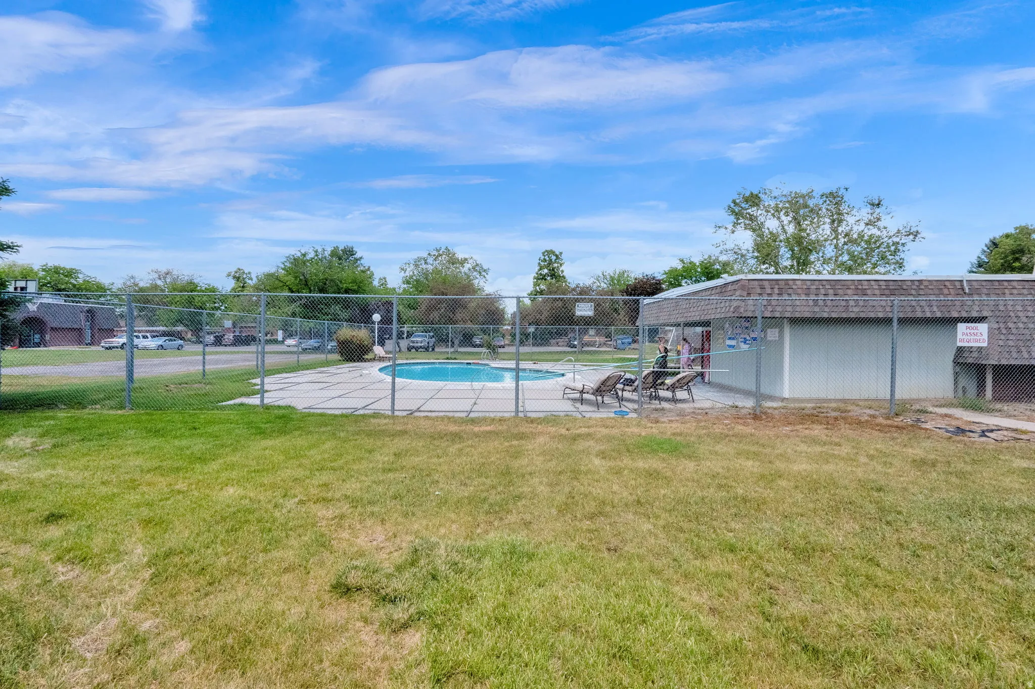 Outdoor swimming pool area featuring a concrete deck and privacy fencing