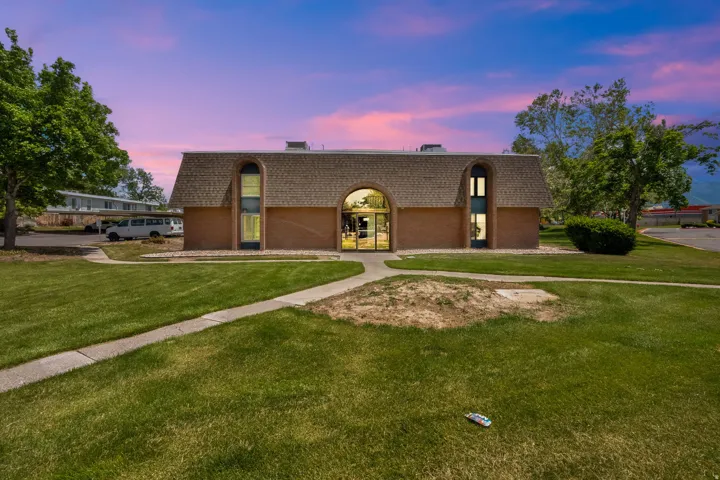 Brick-clad building with a prominent arched entry and a gambrel-style roof