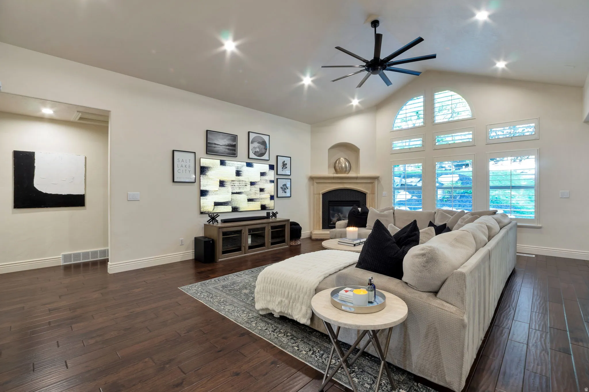 Vaulted ceilings complement a fireplace with a stone mantel