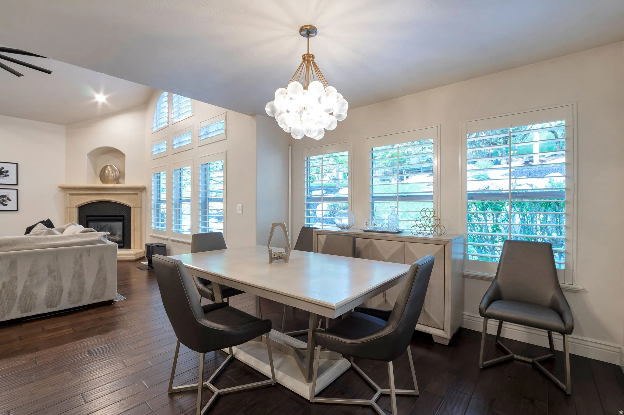 Open-concept dining area featuring dark wood-finish flooring and a contemporary chandelier