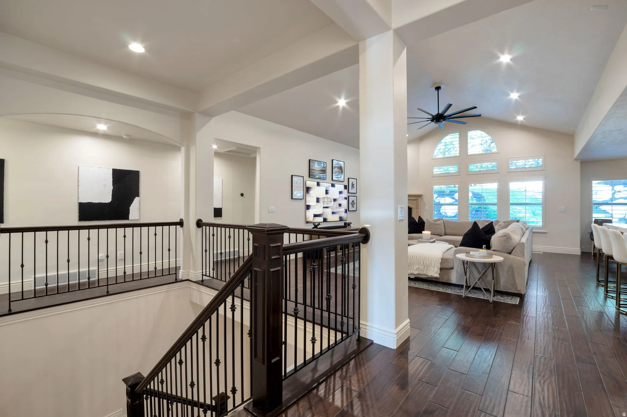Open-concept living space featuring wood-finish flooring, a vaulted ceiling, and recessed lighting