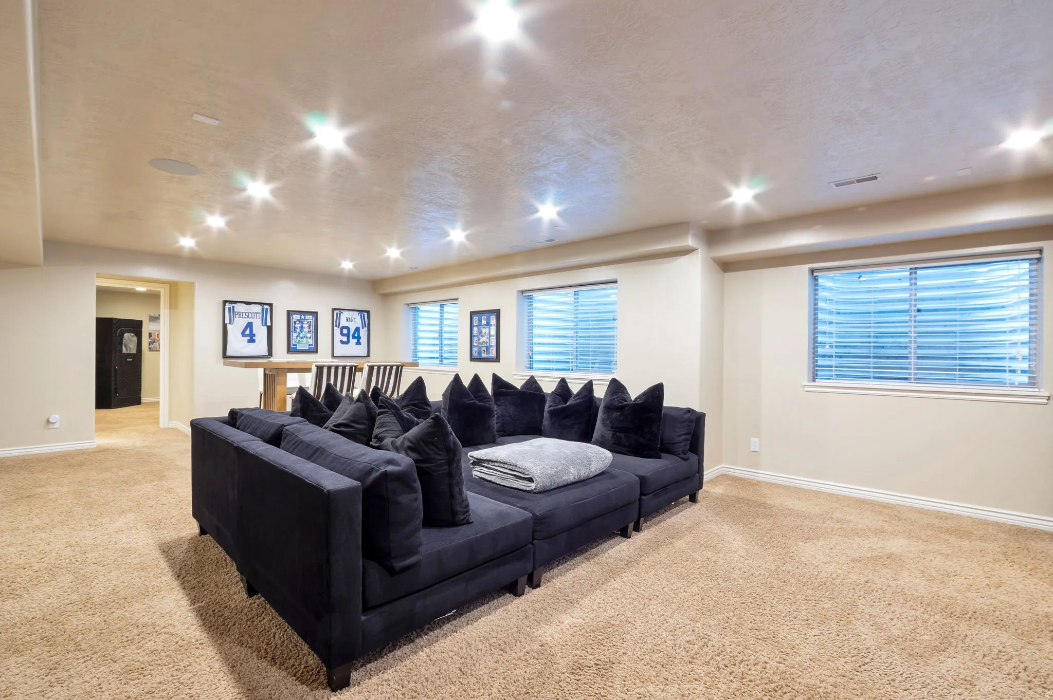 Spacious lower level featuring plush carpet flooring, recessed lighting, and two egress windows with blinds