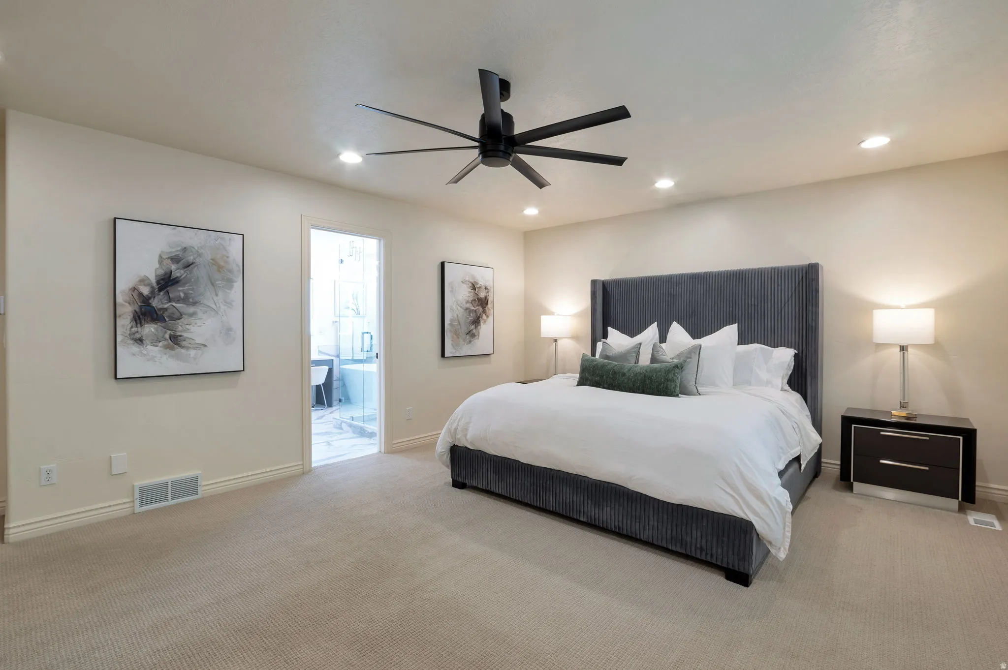 Carpeted room featuring a ceiling fan with integrated lighting, recessed lighting, and a doorway leading to a bathroom with a freestanding tub