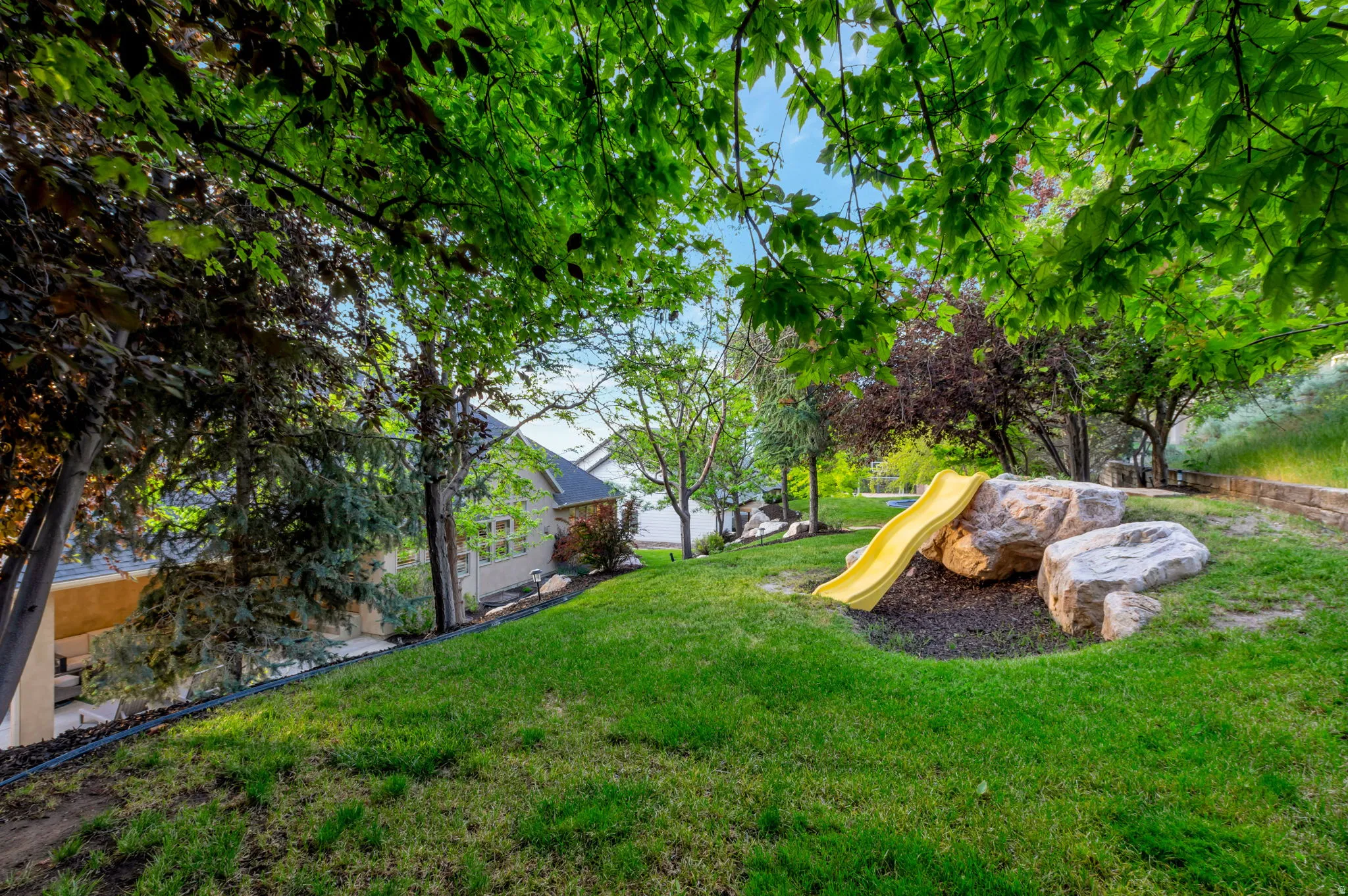 Expansive grassy lawn with established trees providing natural shade