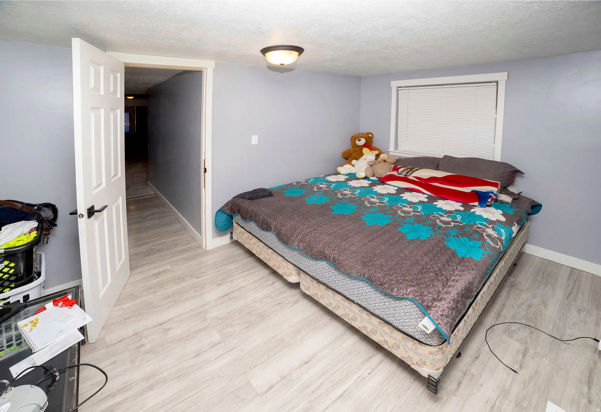 Bedroom featuring light wood-finish flooring and a white paneled door with black hardware