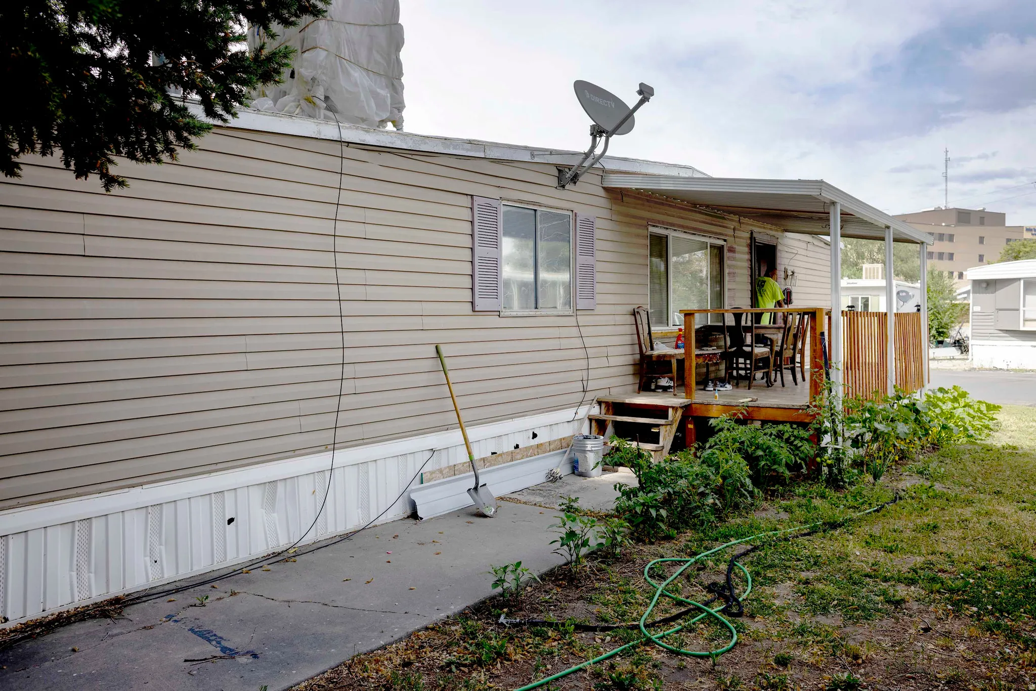 Exterior siding with a covered porch featuring a wooden deck