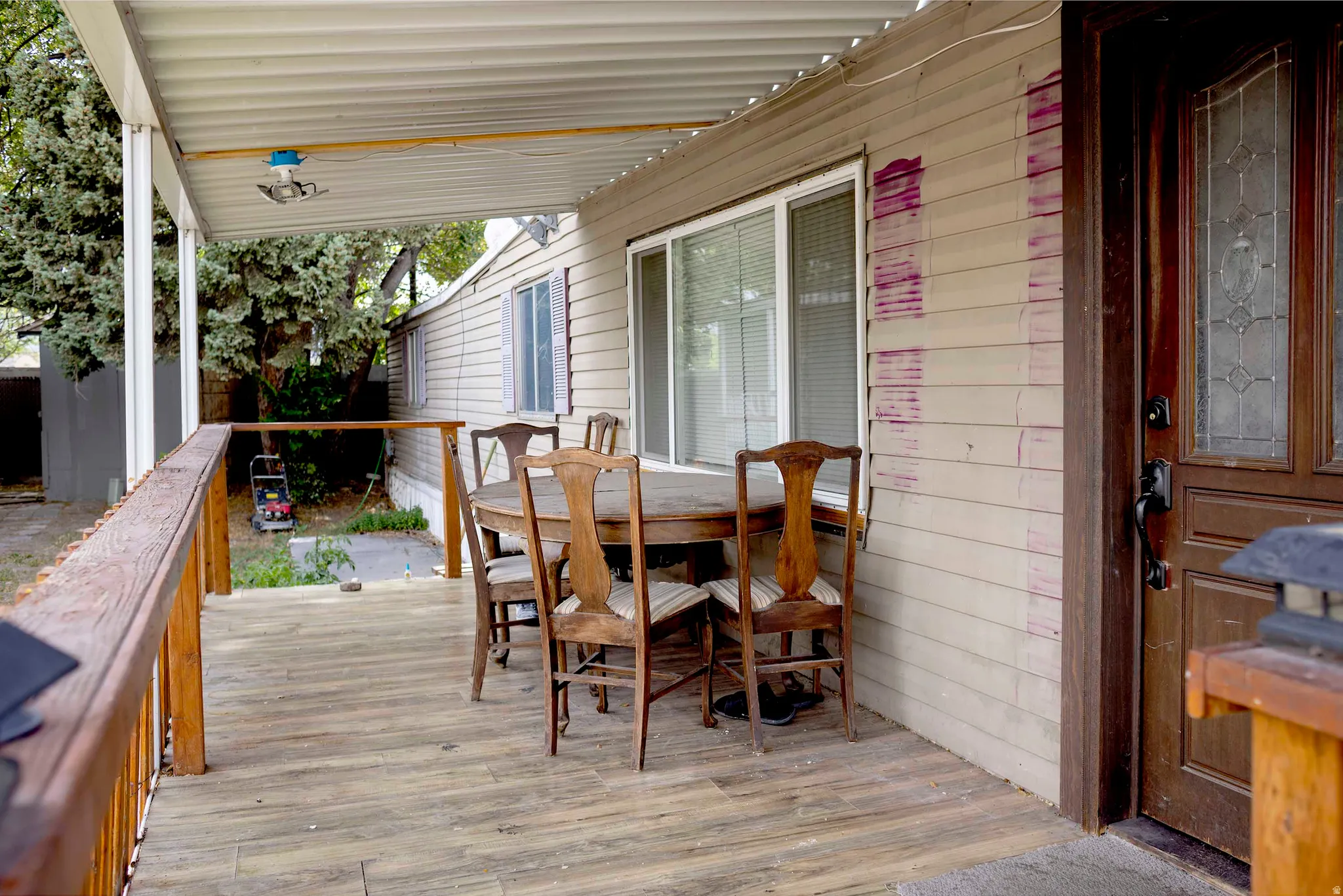 Covered porch featuring wood-finish flooring and a wood railing