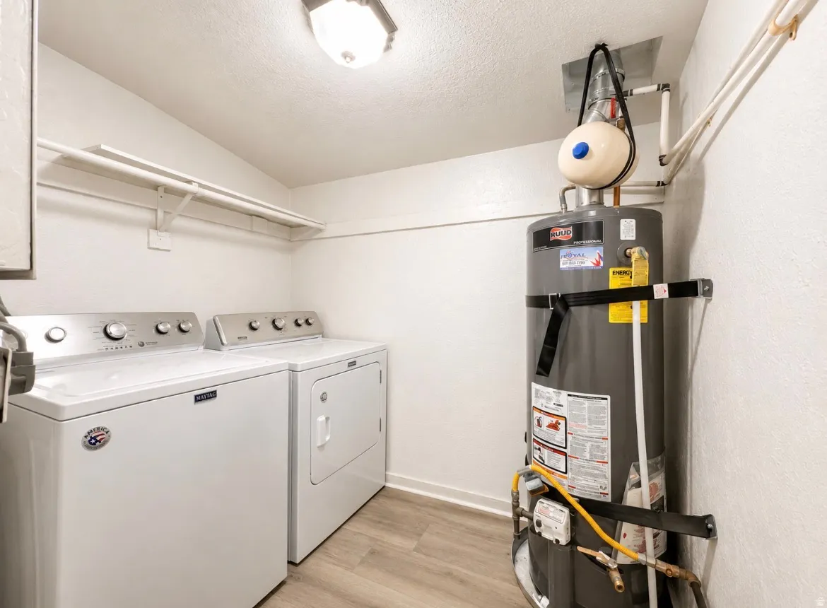 Unit 2 laundry and  utility space featuring light wood-finish flooring, a contemporary ceiling light fixture, and a water heater