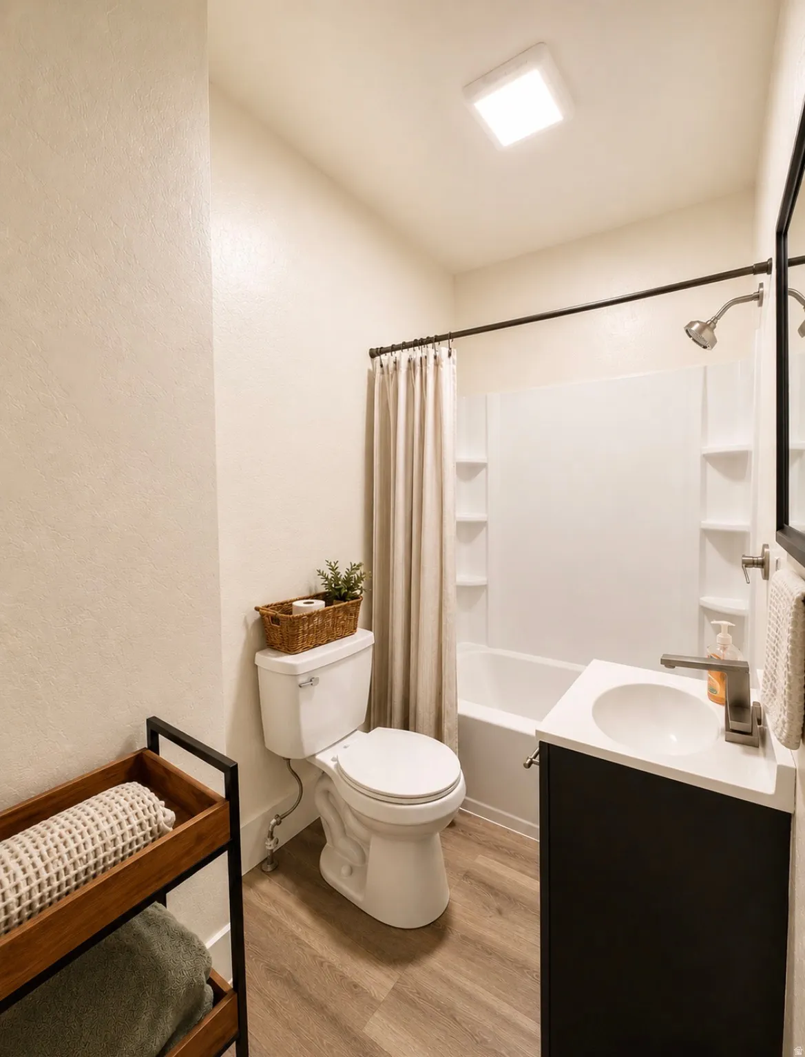 Unit 2 Full bathroom with a white tub-shower combination, dark vanity, and wood-finish flooring