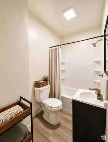 Unit 2 Full bathroom with a white tub-shower combination, dark vanity, and wood-finish flooring