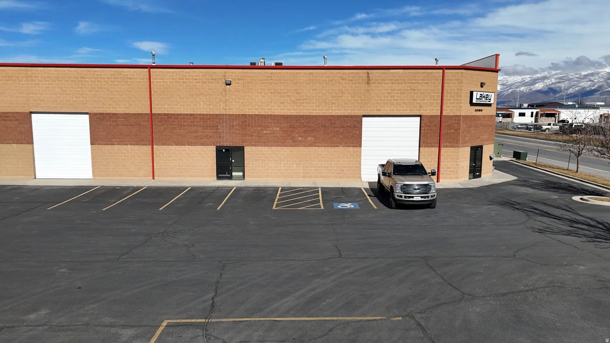 Light brown brick exterior with a red accent band and roof trim