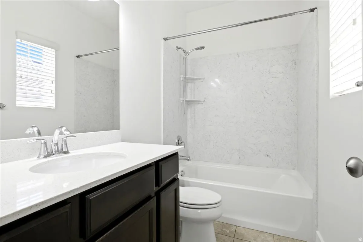 Bathroom featuring a dark wood-finish vanity with a white countertop and undermount sink, a chrome faucet, and a large mirror