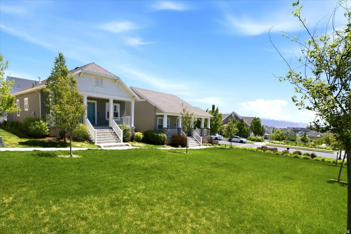Classic bungalow style residence featuring a prominent covered porch with white columns, a vibrant blue entry door, and a light-colored gable roof