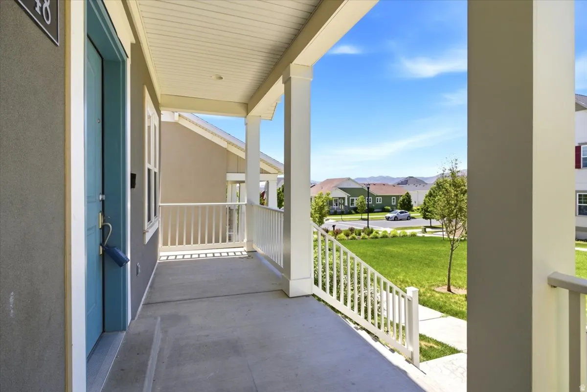 Covered porch with a blue entry door and white railing
