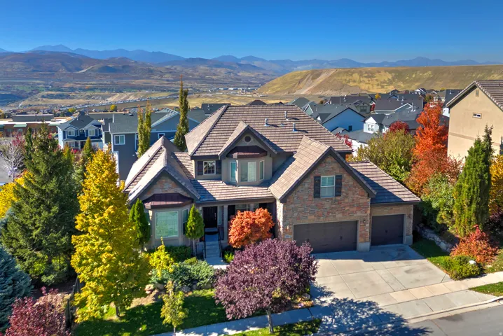 Stone and siding exterior with a two-car garage and mature landscaping