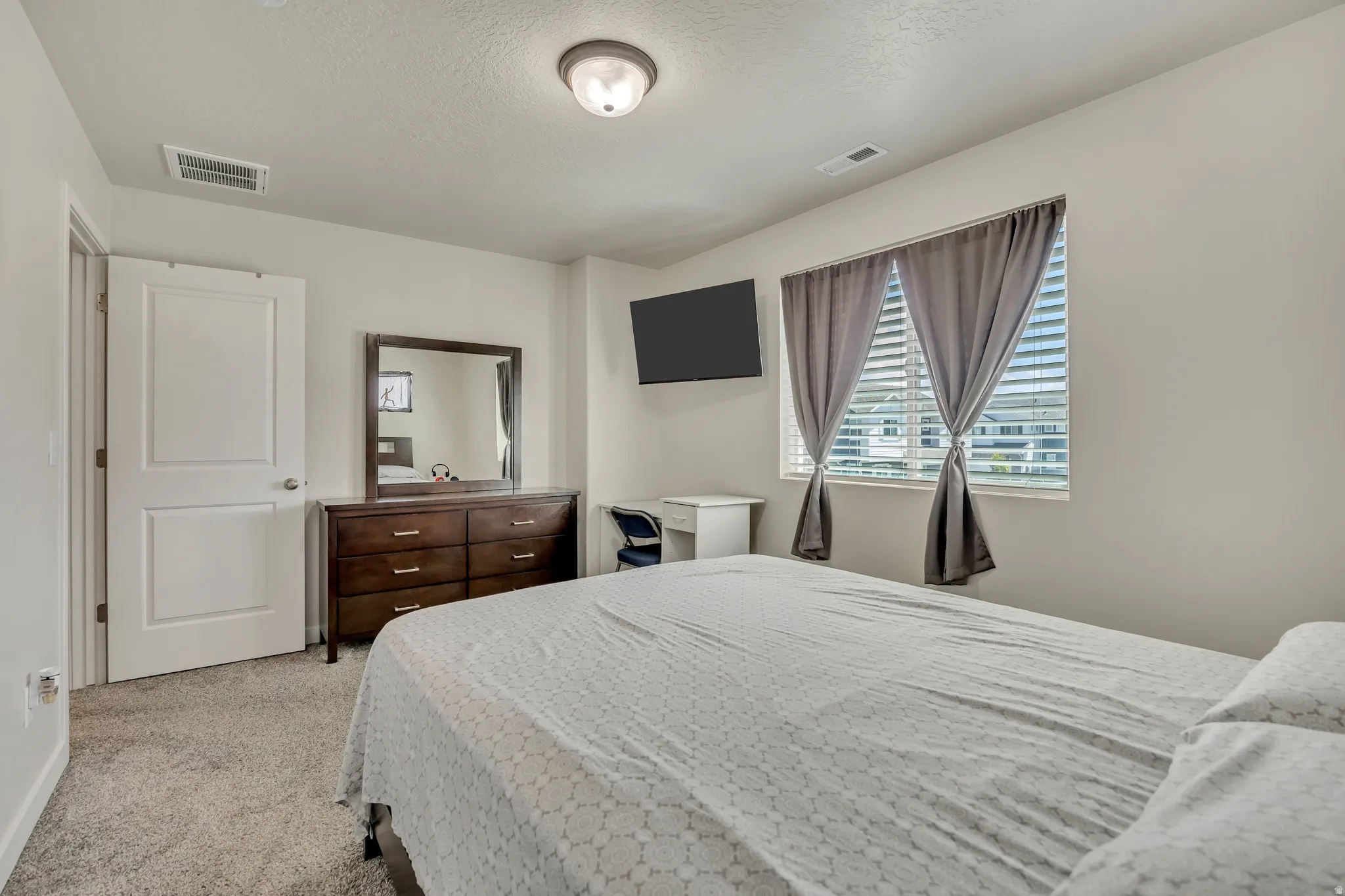 Neutral toned room featuring plush carpeting and a flush-mount ceiling light