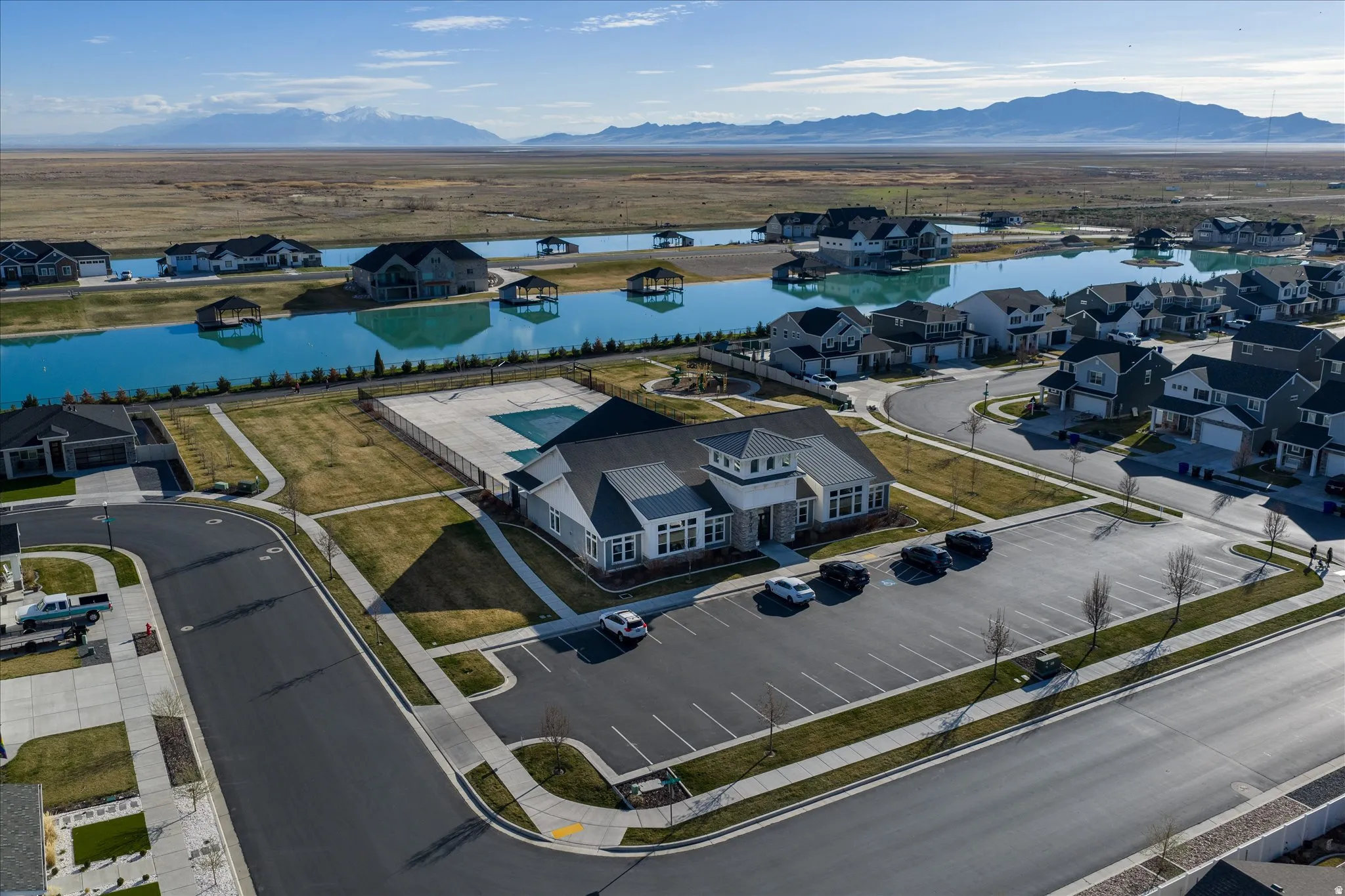 Aerial community perspective featuring a central clubhouse with an outdoor swimming pool and surrounding residential properties