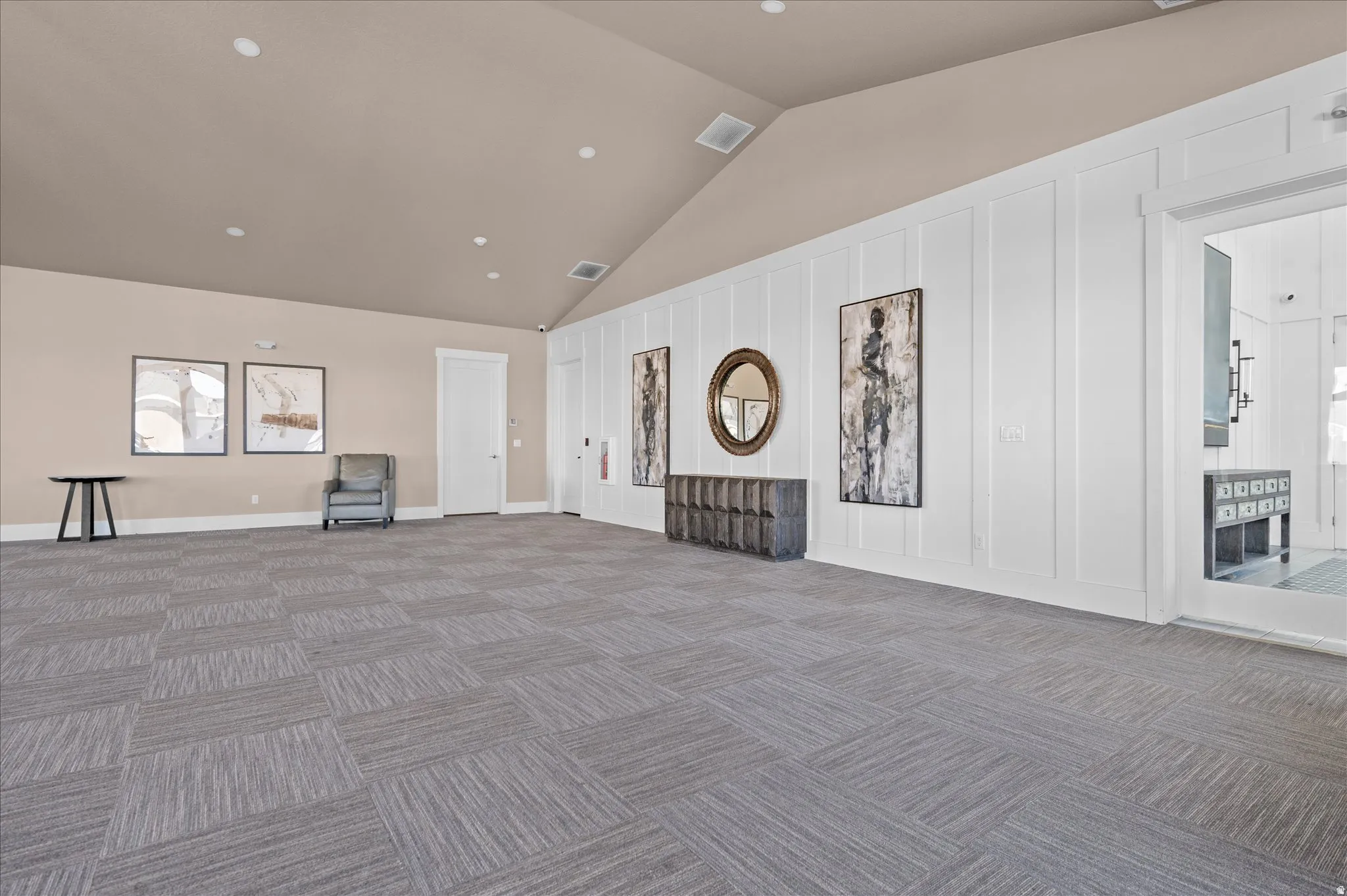 Expansive club house room featuring patterned carpet flooring and a vaulted ceiling with recessed lighting