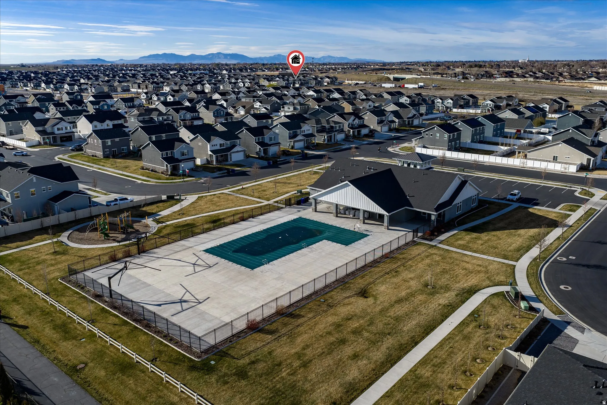 Community recreation area featuring a covered pool, clubhouse building, and playground