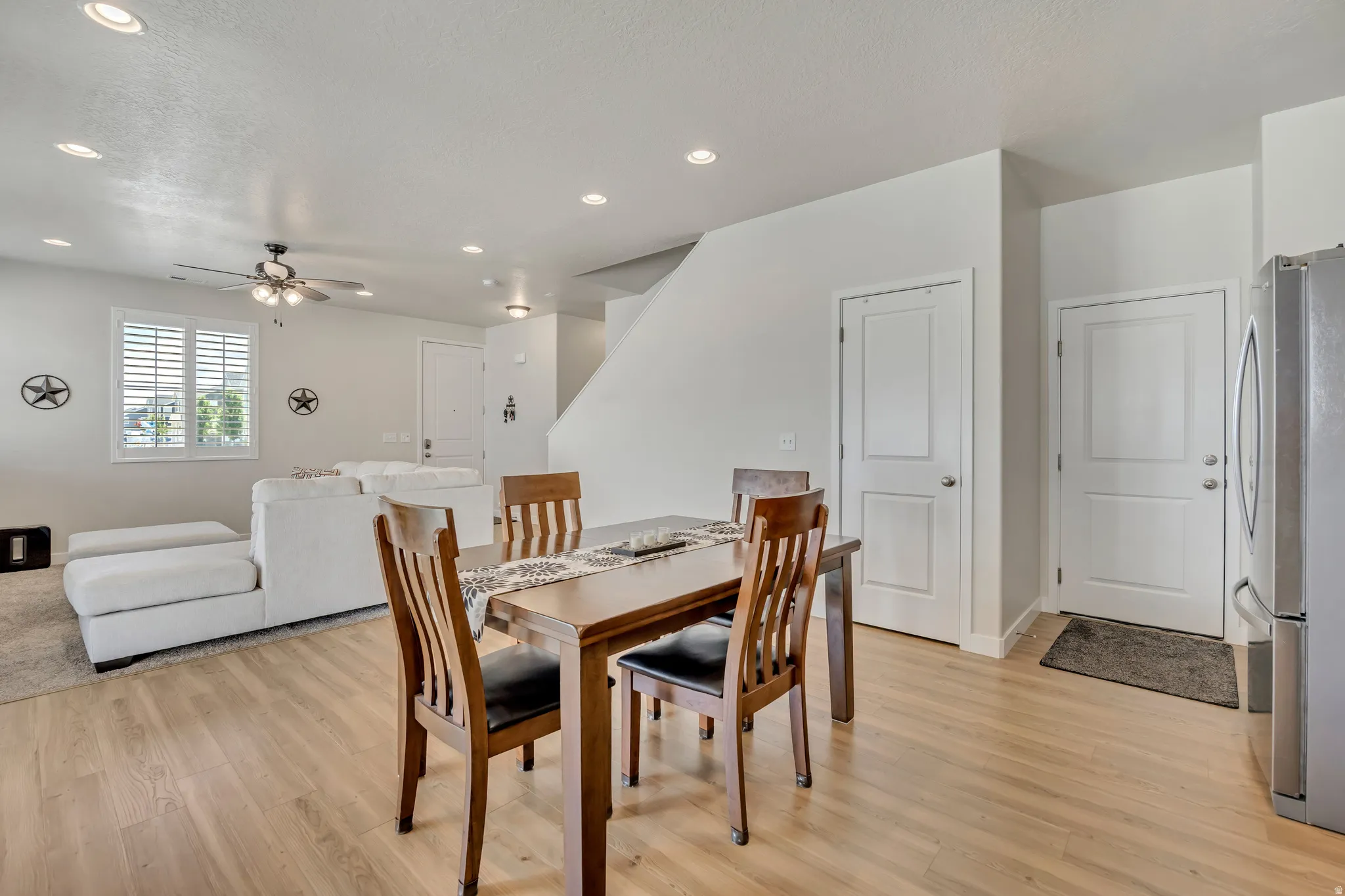 Open-concept living space with wood-finish flooring extending into the dining area