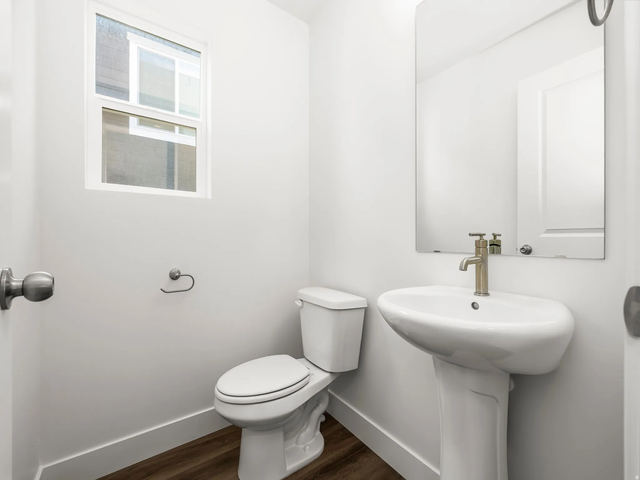 Pedestal sink featuring a brushed nickel faucet and a rectangular mirror
