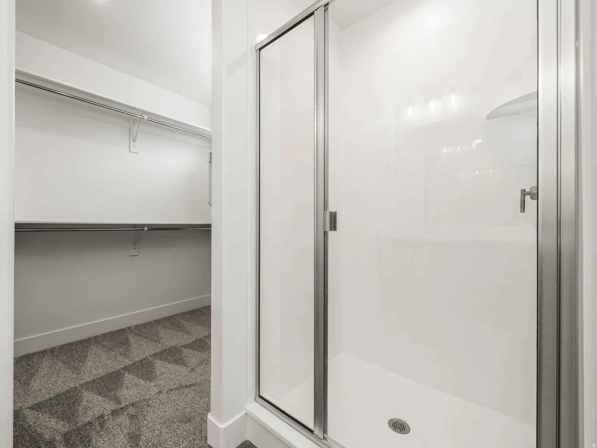Walk-in shower with a glass enclosure and chrome fixtures