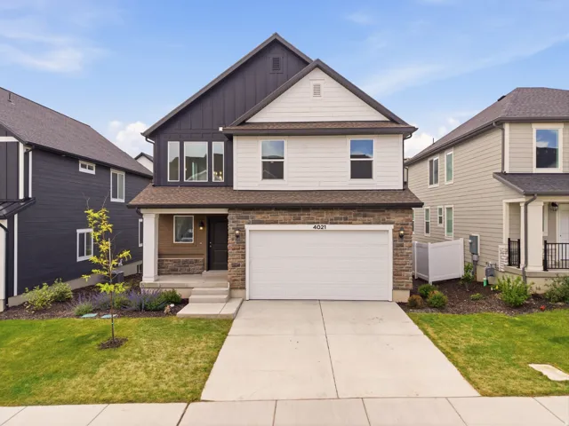 Two-story residence featuring a combination of horizontal siding, vertical board and batten siding, and stone veneer accents