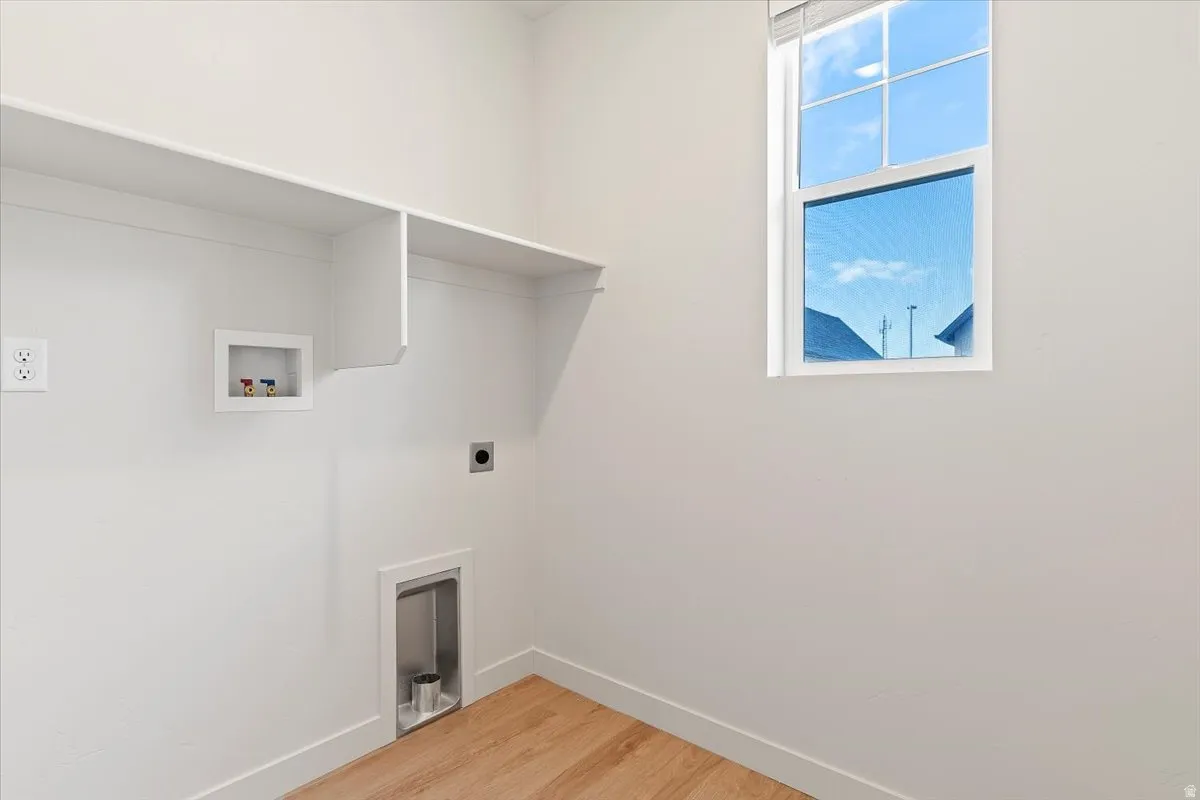 Utility room featuring wood-finish flooring, white walls, and built-in shelving