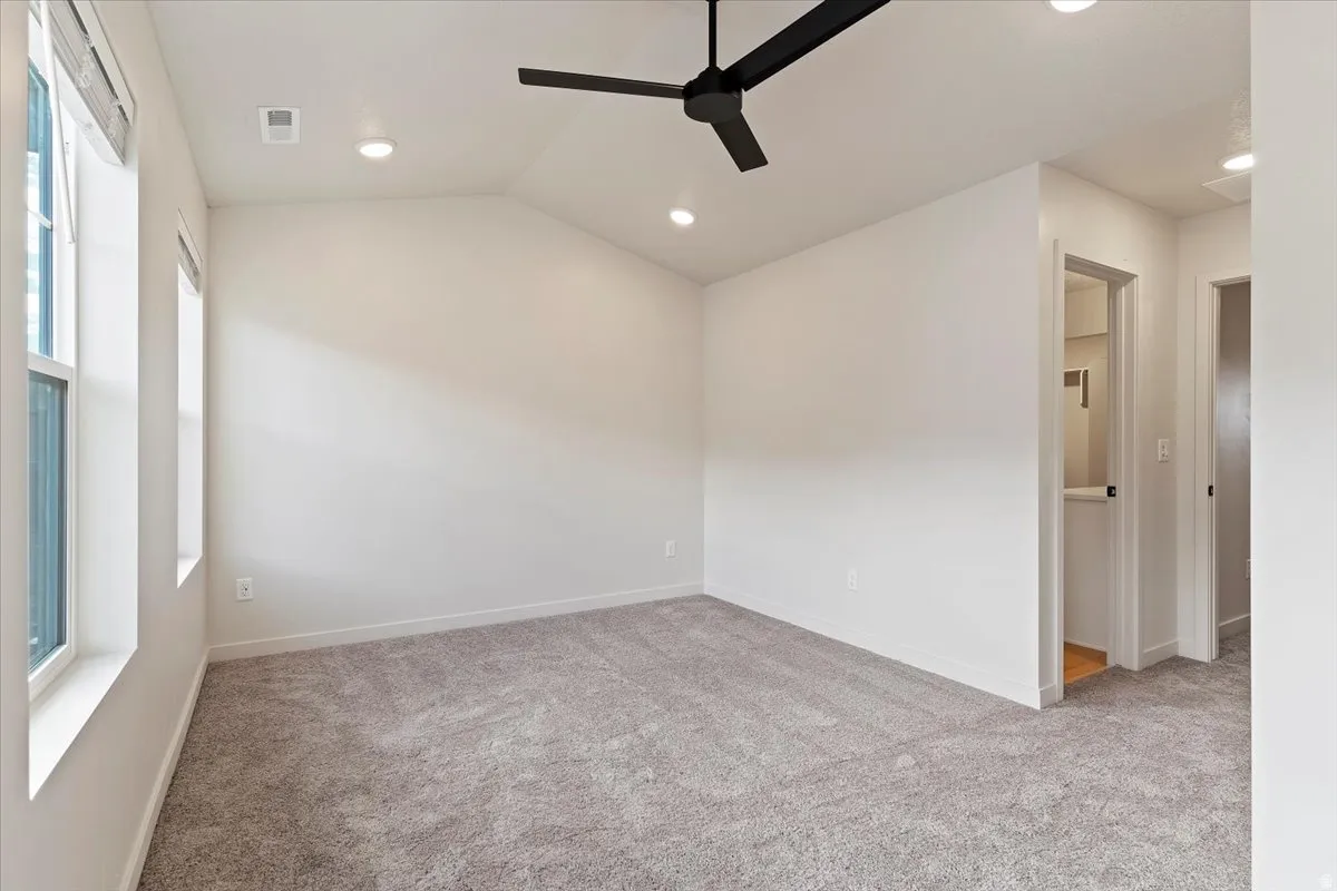 Spacious room featuring vaulted ceilings, recessed lighting, and a contemporary ceiling fan