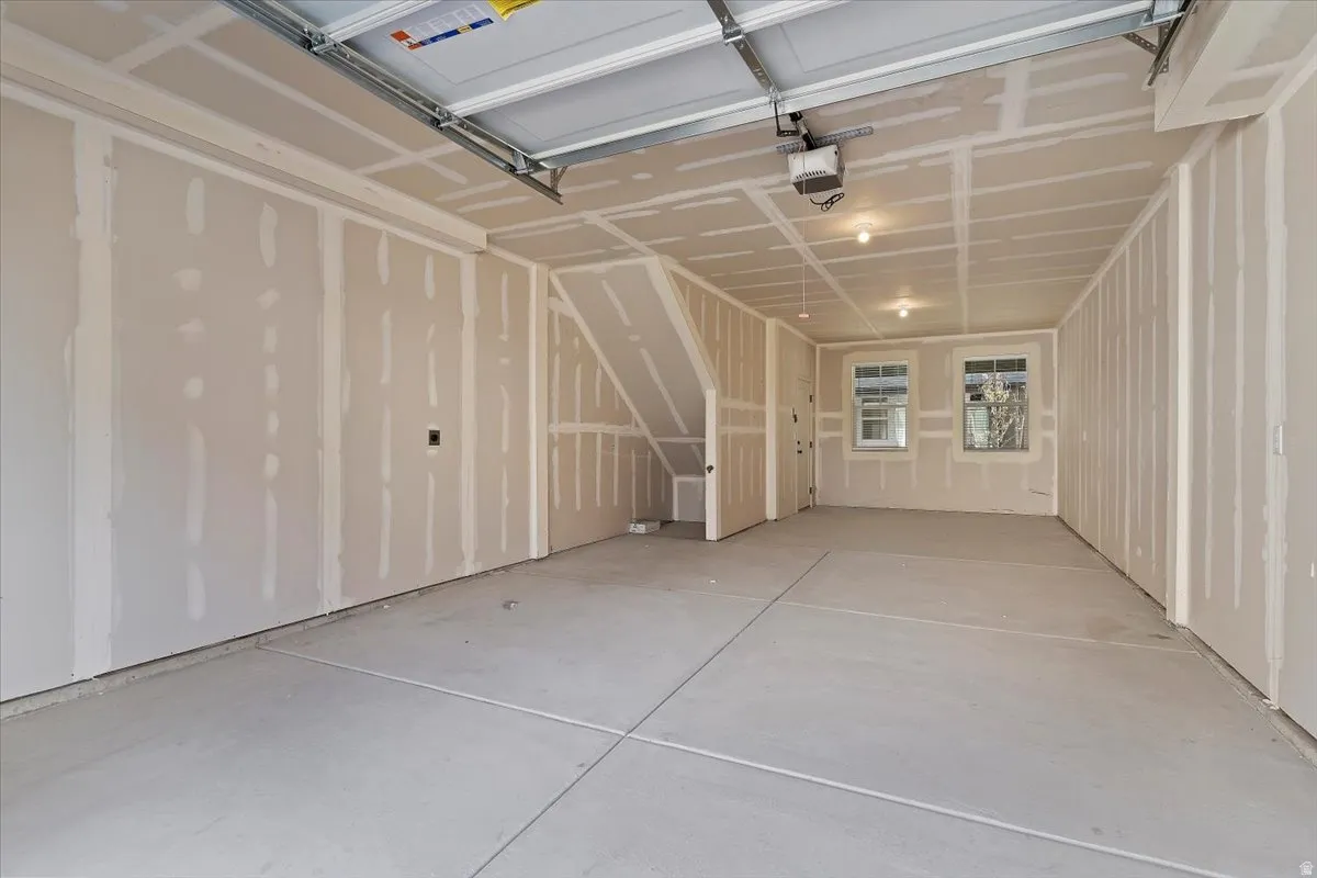Spacious garage featuring a concrete floor, two windows providing natural light, and an overhead garage door mechanism