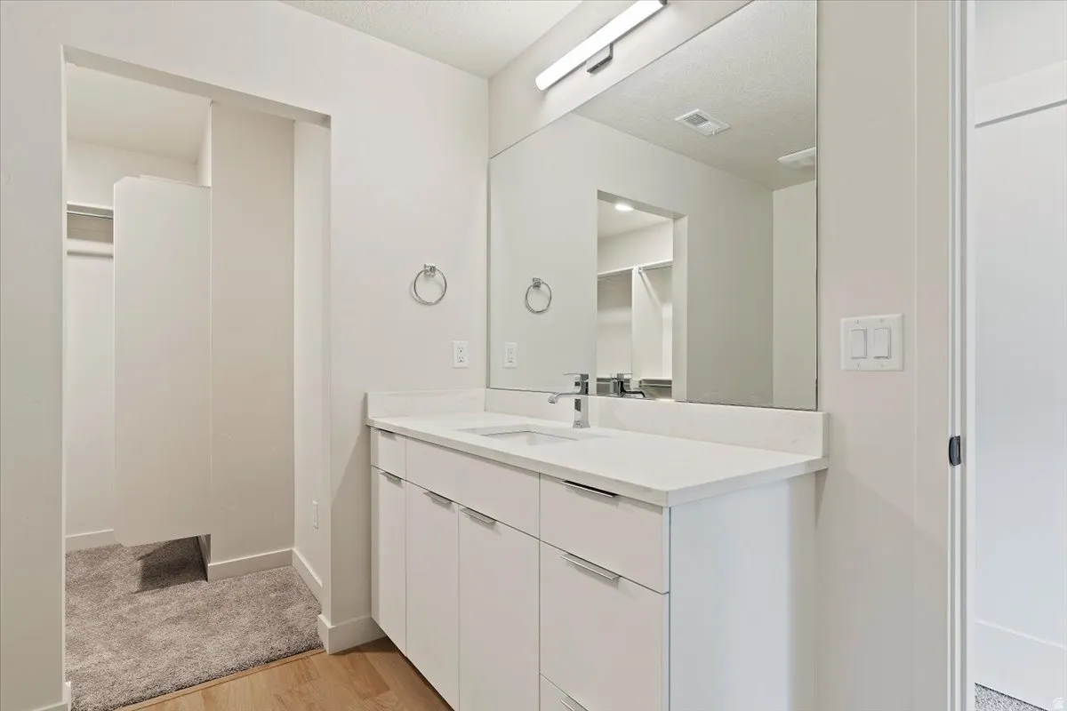 Contemporary vanity featuring a single basin, integrated countertop, and storage cabinetry