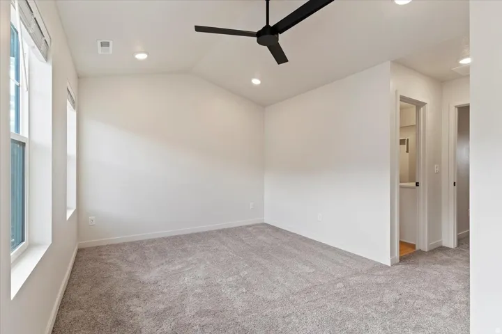 Spacious room featuring vaulted ceilings, recessed lighting, and a contemporary ceiling fan