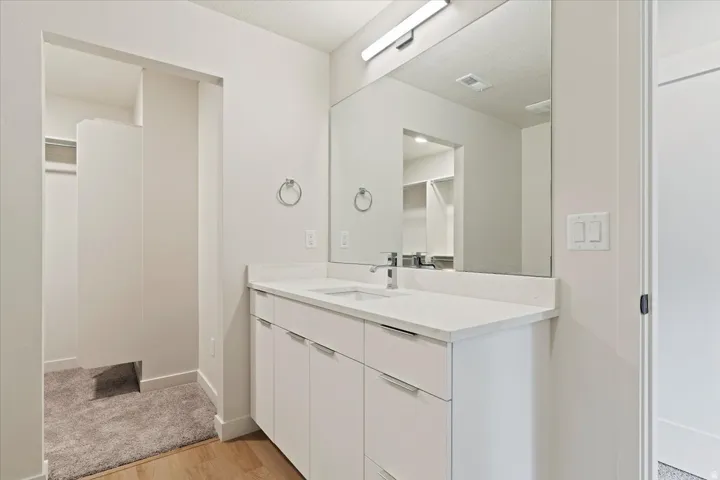Contemporary vanity featuring a single basin, integrated countertop, and storage cabinetry