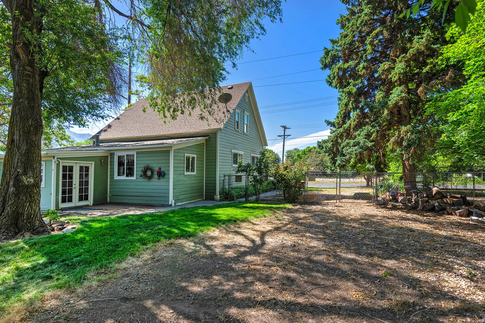 Green siding exterior with a light-toned shingle roof