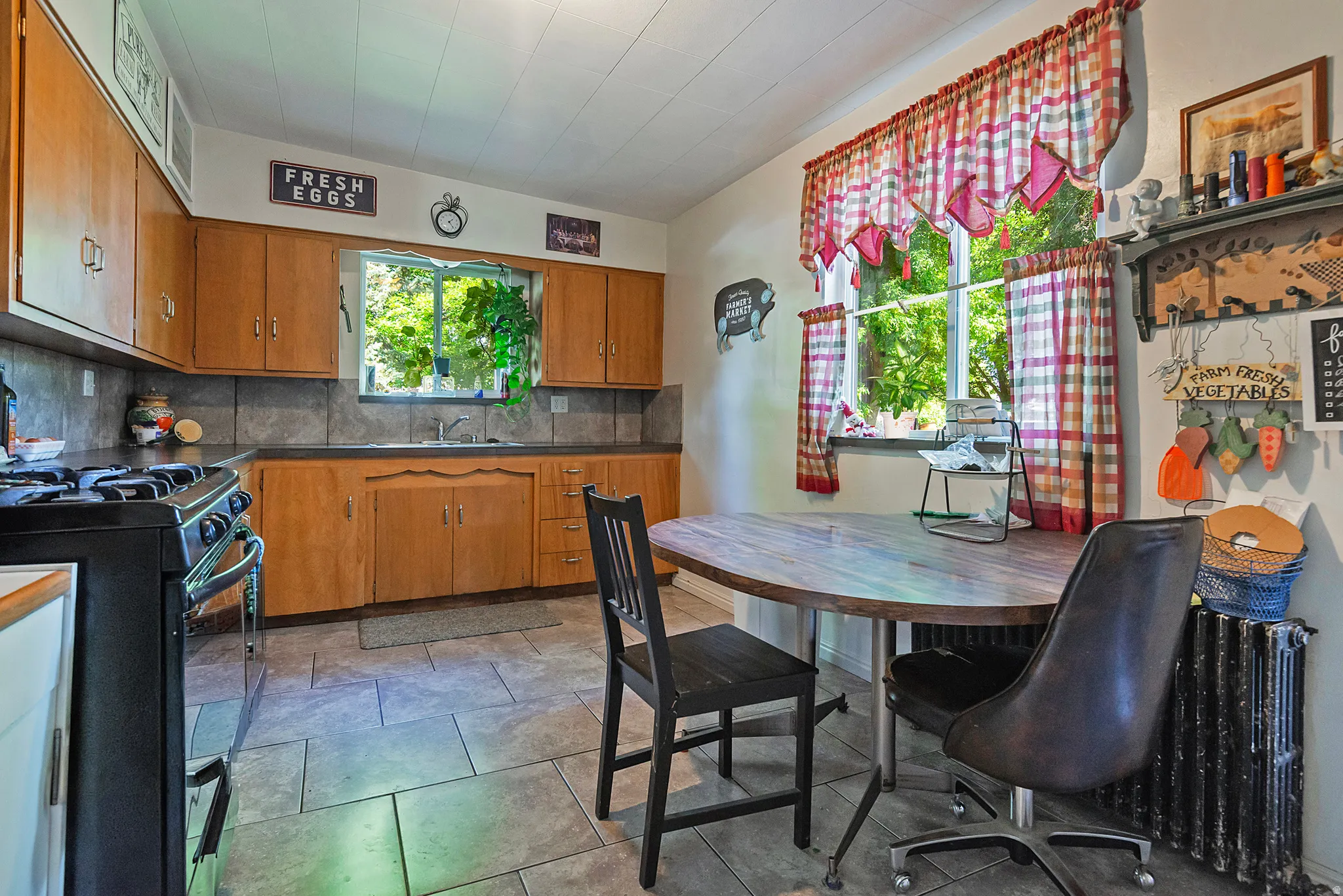 Kitchen featuring wood cabinetry, a built-in sink, and tile flooring