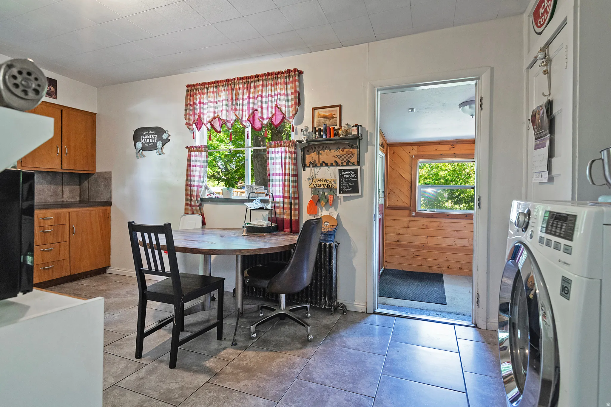 Kitchen area featuring wood-finish cabinetry, a window with natural light, and tile flooring