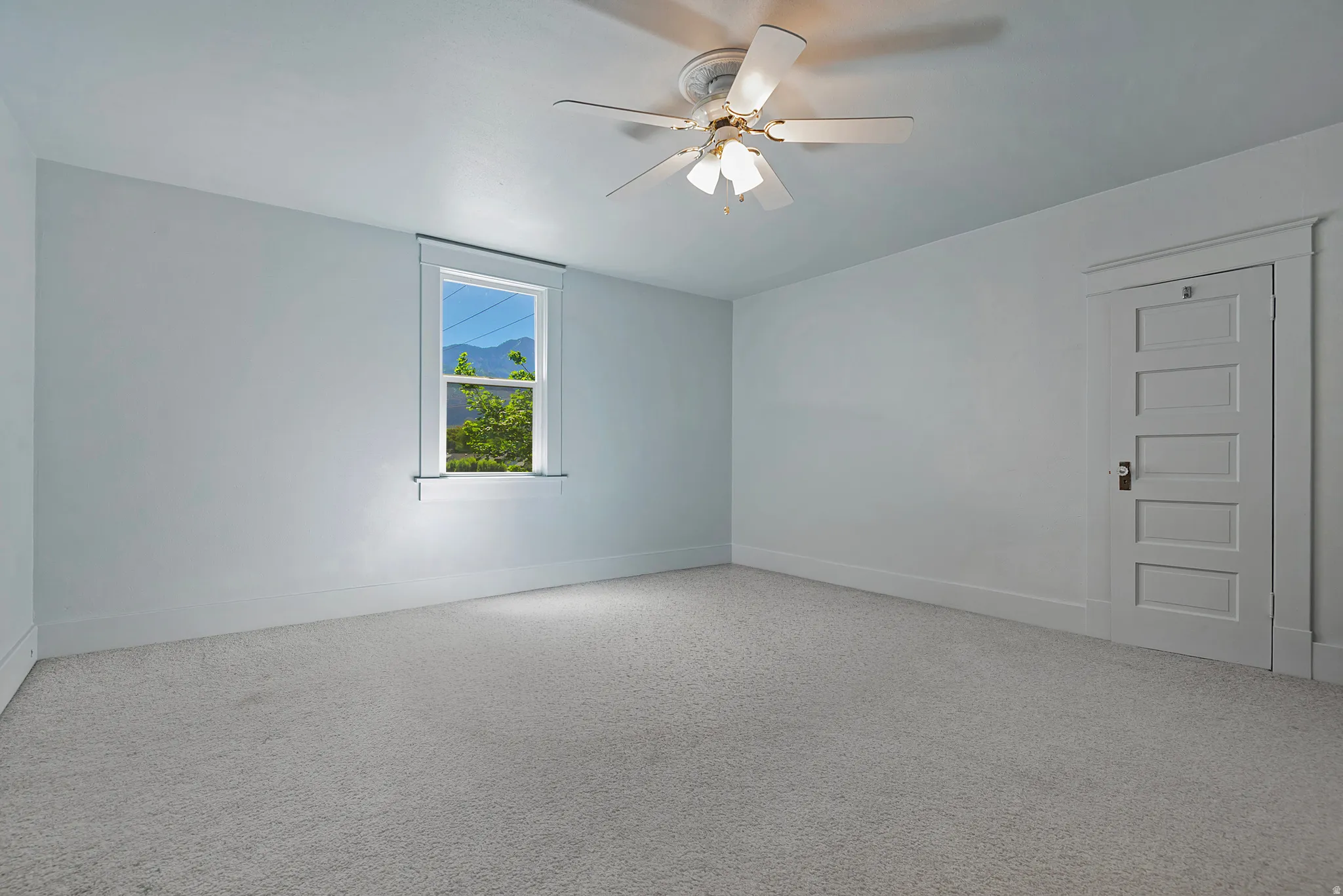 Spacious room featuring light-colored walls and soft carpeting