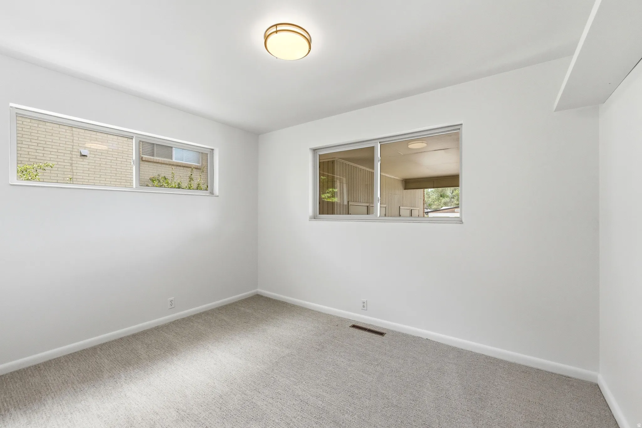 White-painted room featuring light gray carpet flooring