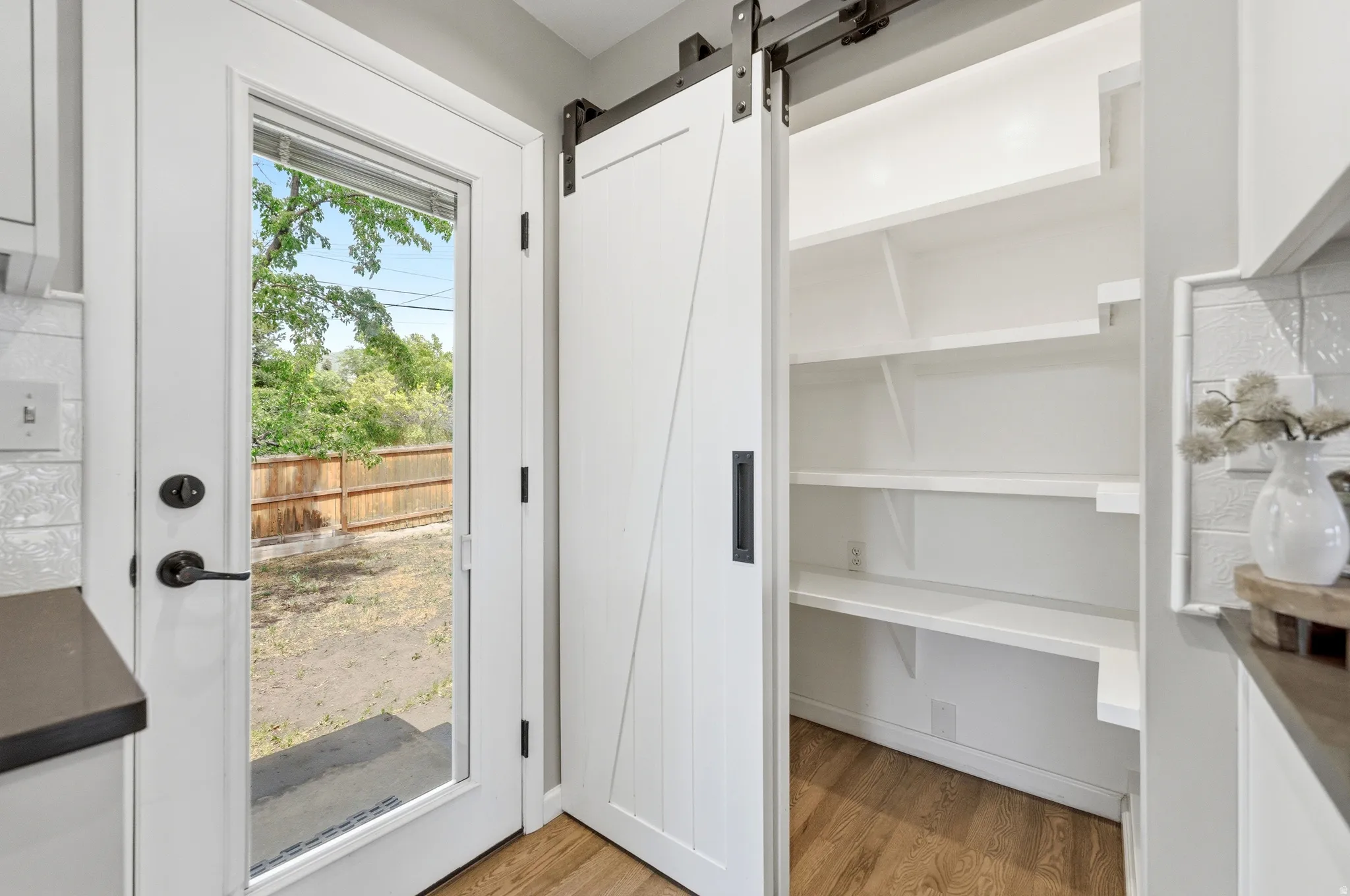 White barn door pantry featuring multiple built-in shelves