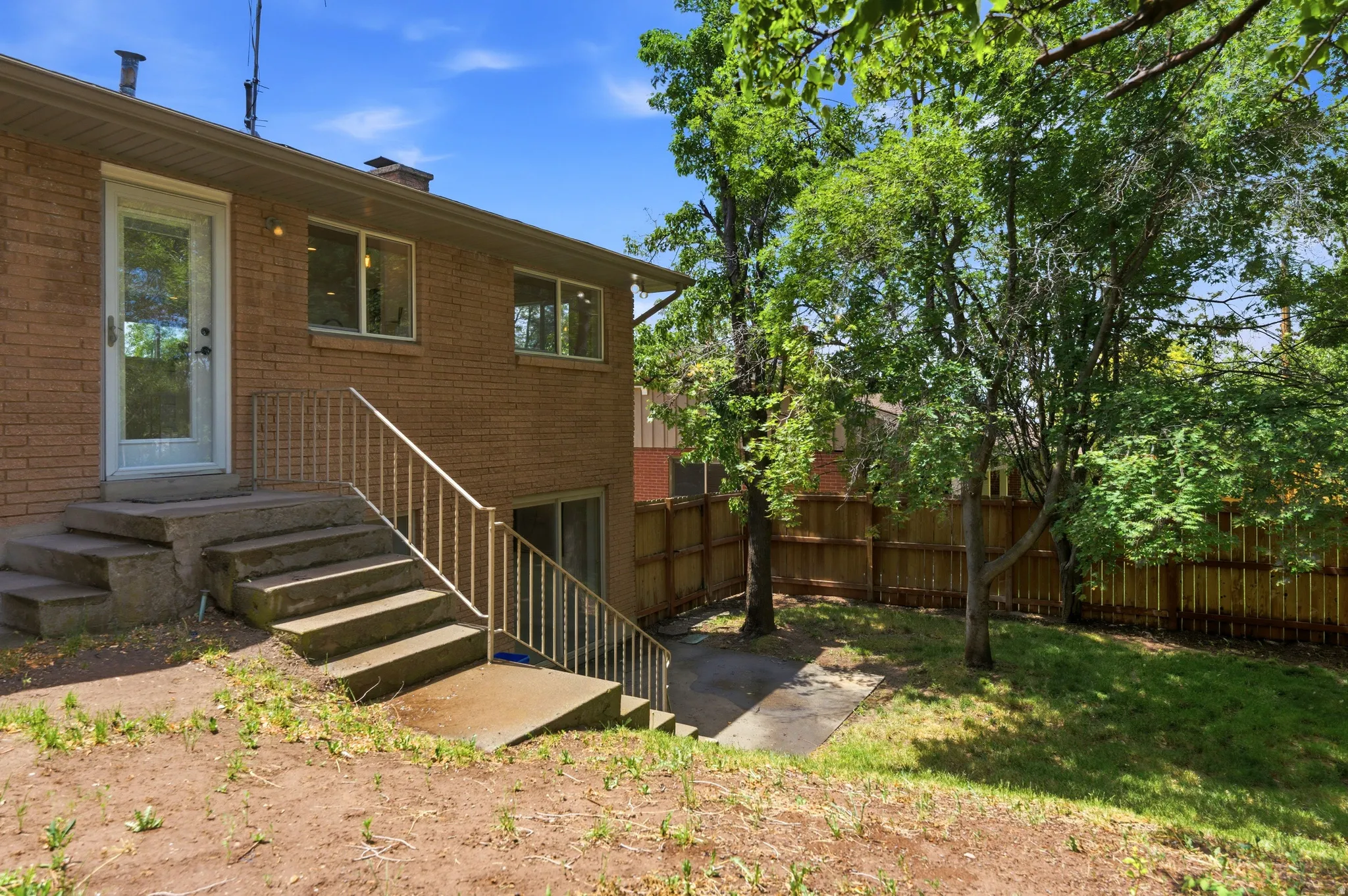 Brick exterior featuring a full-light storm door and multiple windows providing natural light