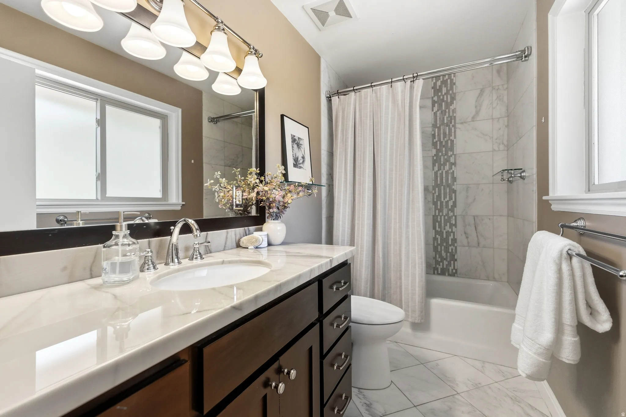 Bathroom featuring a dark wood-finish vanity with a white countertop and undermount sink
