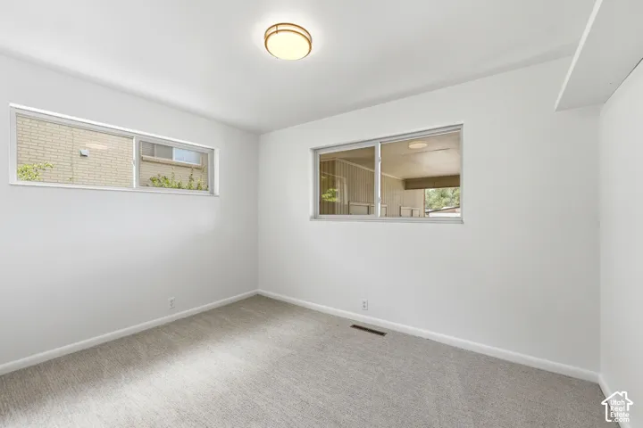 White-painted room featuring light gray carpet flooring