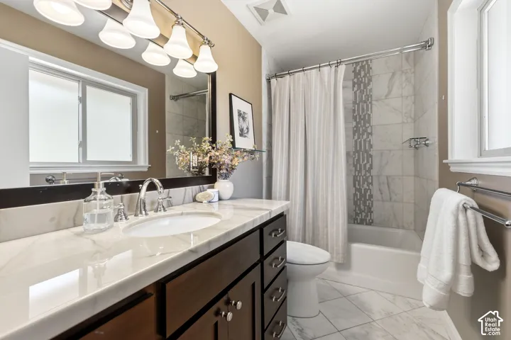 Bathroom featuring a dark wood-finish vanity with a white countertop and undermount sink