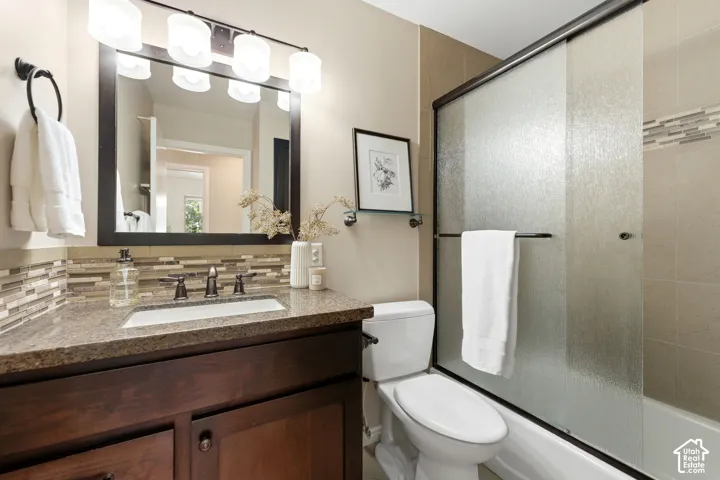 Vanity with a granite-style countertop, undermount sink, and dark wood cabinetry
